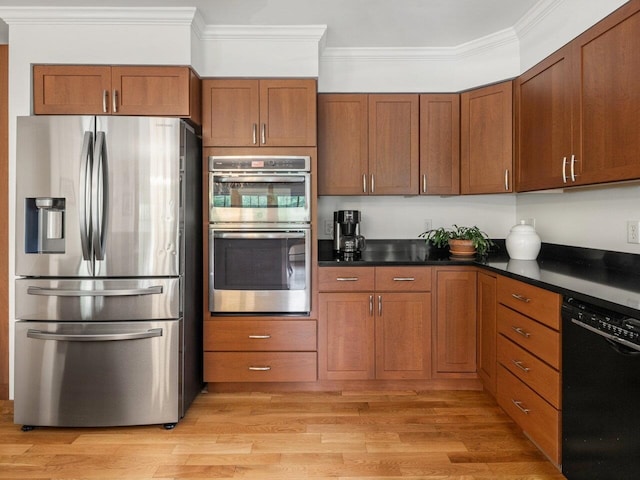 278 S Cove Rd, Burlington, VT 05401 - kitchen featuring stainless steel appliances, ornamental molding, brown cabinets, light wood-style floors, and dark countertops