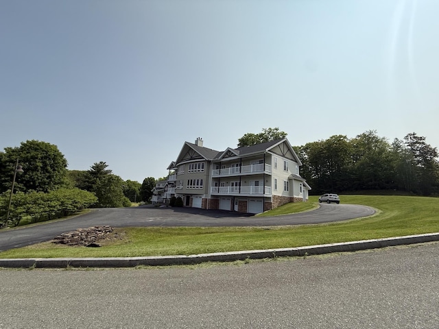 120 Pepin Dr Unit B 6, Newport City, VT 05855 - view of front of property with asphalt driveway, a chimney, a front yard, a balcony, and an attached garage