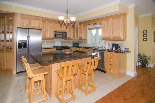 120 Pepin Dr Unit B 6, Newport City, VT 05855 - kitchen featuring stainless steel appliances, a sink, tasteful backsplash, a kitchen bar, and light tile patterned flooring