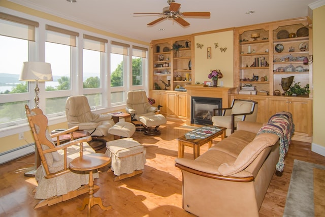 120 Pepin Dr Unit B 6, Newport City, VT 05855 - living area featuring built in shelves, wood finished floors, ornamental molding, ceiling fan, and a glass covered fireplace