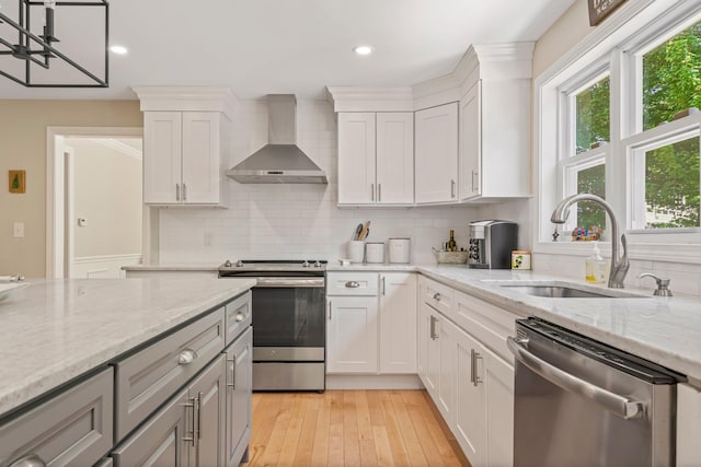 78 Hitching Post Ln, Bedford, NH 03110 - kitchen featuring wall chimney range hood, appliances with stainless steel finishes, a sink, decorative backsplash, and white cabinets