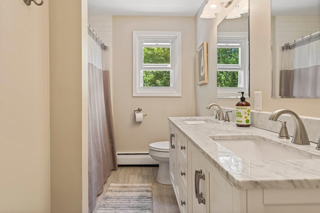 78 Hitching Post Ln, Bedford, NH 03110 - full bathroom with a baseboard radiator, double vanity, toilet, wood finished floors, and a shower with shower curtain