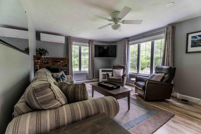 82 Garden Cir, Laconia, NH 03246 - living room with a wall mounted air conditioner, a baseboard heating unit, baseboards, a ceiling fan, and wood finished floors