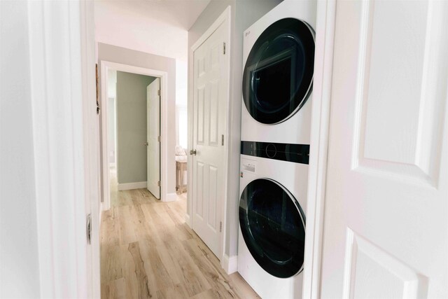 82 Garden Cir, Laconia, NH 03246 - laundry room featuring stacked washer and clothes dryer, light wood-style floors, and baseboards