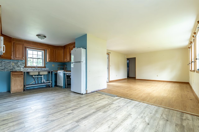 2 Ramsey Dr, Rochester, NH 03839 - kitchen with freestanding refrigerator, light wood-style floors, brown cabinets, open floor plan, and baseboards