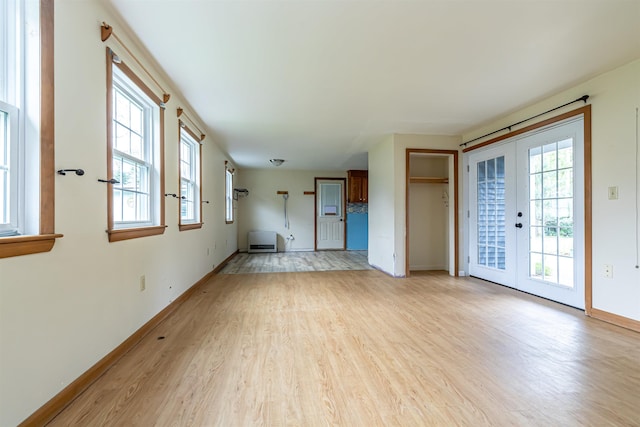 2 Ramsey Dr, Rochester, NH 03839 - unfurnished living room featuring light wood-style floors, french doors, plenty of natural light, and baseboards