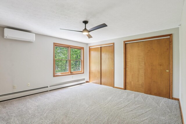 620 Hackett Hill Rd, Manchester, NH 03102 - unfurnished bedroom with baseboard heating, an AC wall unit, two closets, carpet flooring, and ceiling fan