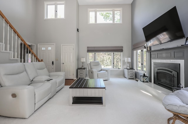 58 Hickory Ln, Windham, NH 03087 - carpeted living room featuring a towering ceiling, a fireplace with raised hearth, and stairway