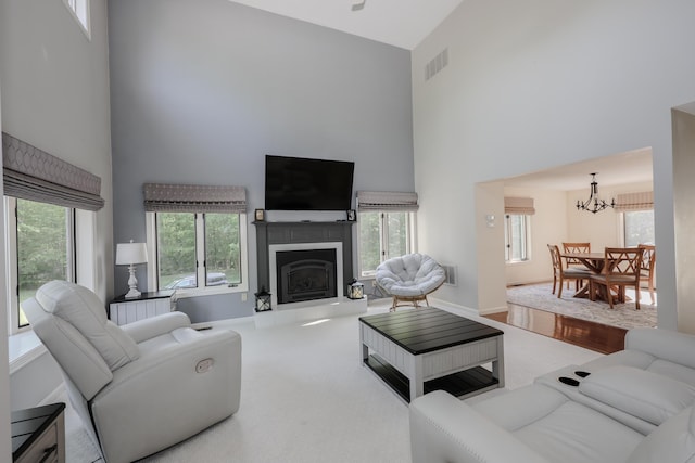 58 Hickory Ln, Windham, NH 03087 - carpeted living area with a high ceiling, a chandelier, a fireplace with raised hearth, and baseboards