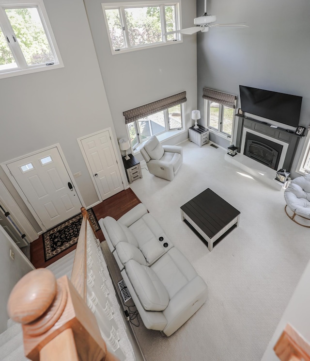 58 Hickory Ln, Windham, NH 03087 - living room with a towering ceiling, plenty of natural light, ceiling fan, carpet flooring, and a glass covered fireplace