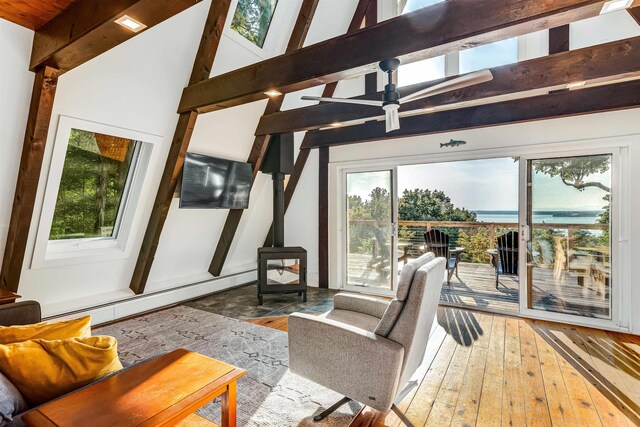 171 Cold Spring Rd, Milton, VT 05478 - living area featuring a wood stove, hardwood / wood-style flooring, a baseboard heating unit, a ceiling fan, and beam ceiling