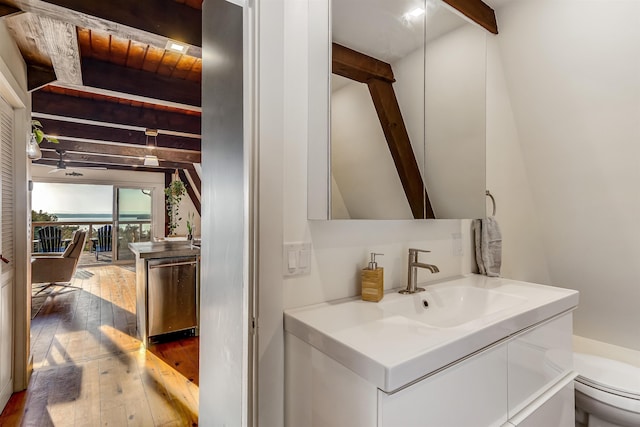 171 Cold Spring Rd, Milton, VT 05478 - bathroom featuring beamed ceiling, hardwood / wood-style floors, vanity, and toilet