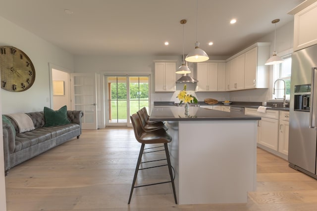 346 Elizabeths Ln Unit 13, Morristown, VT 05661 - kitchen featuring stainless steel appliances, a sink, dark countertops, open floor plan, and white cabinets