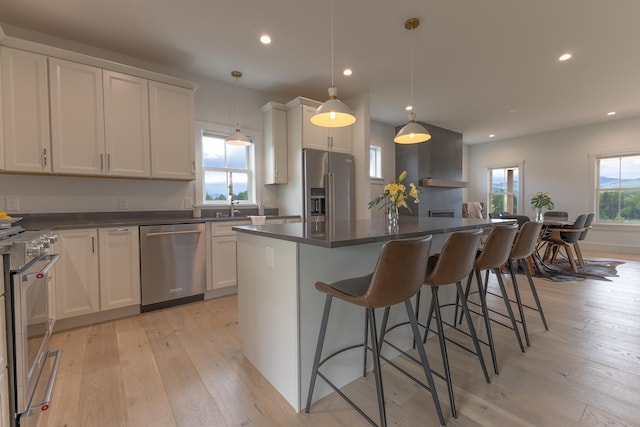 346 Elizabeths Ln Unit 13, Morristown, VT 05661 - kitchen featuring premium appliances, dark countertops, a center island, light wood-style floors, and recessed lighting