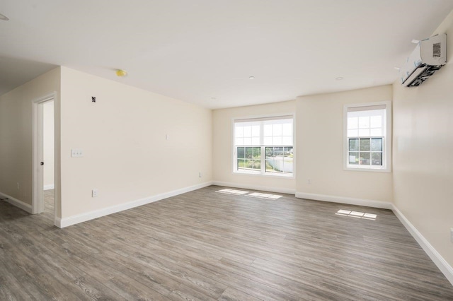 725 Central Ave Unit 103, Dover, NH 03820 - unfurnished room featuring wood finished floors, plenty of natural light, and a wall unit AC