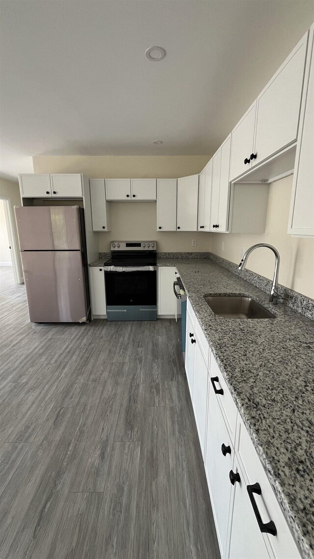 725 Central Ave Unit 103, Dover, NH 03820 - kitchen featuring appliances with stainless steel finishes, dark stone counters, white cabinets, and dark wood-type flooring