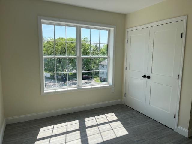725 Central Ave Unit 103, Dover, NH 03820 - unfurnished bedroom with multiple windows, wood finished floors, and a closet