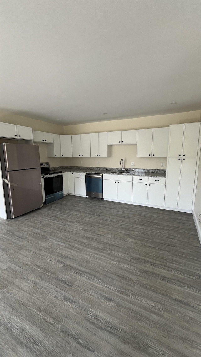 725 Central Ave Unit 103, Dover, NH 03820 - kitchen with appliances with stainless steel finishes, white cabinetry, dark countertops, and dark wood finished floors