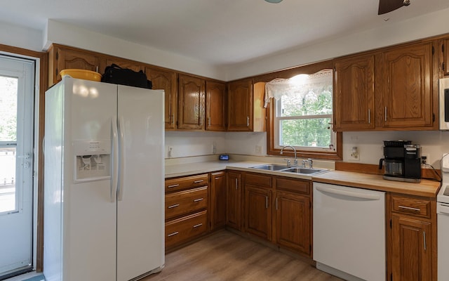 353 N St, Jaffrey, NH 03452 - kitchen featuring white appliances, a sink, light wood-style flooring, light countertops, and brown cabinetry