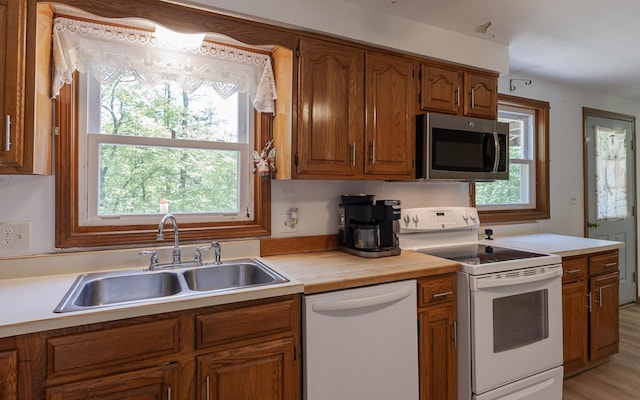 353 N St, Jaffrey, NH 03452 - kitchen with white appliances, a sink, brown cabinets, and healthy amount of natural light