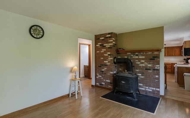 353 N St, Jaffrey, NH 03452 - living room with light wood finished floors, baseboards, and a wood stove