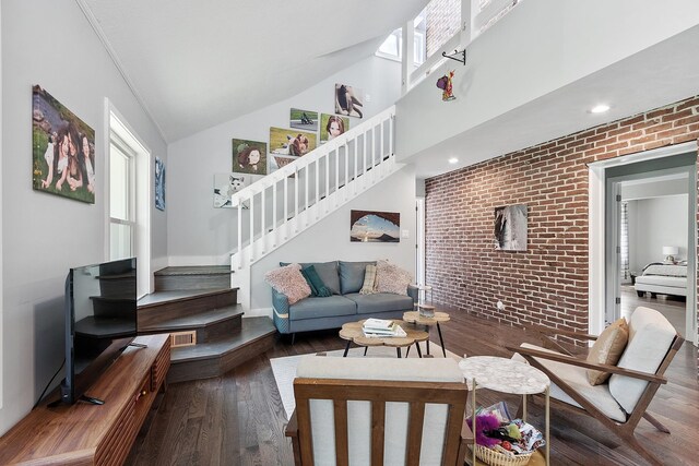 2 Candlewood Rd, Windham, NH 03087 - living area featuring stairway, healthy amount of natural light, brick wall, wood finished floors, and vaulted ceiling