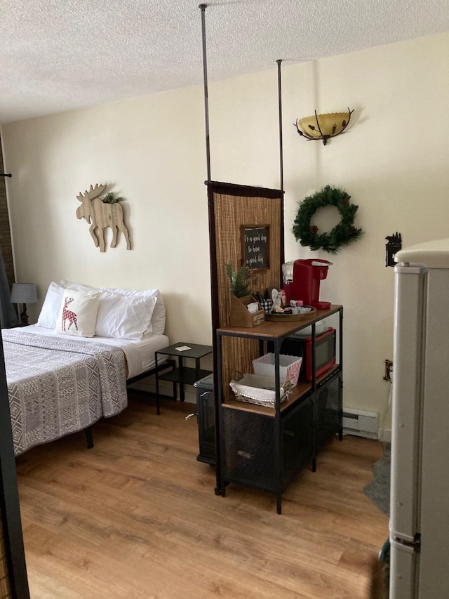 36 Lodge Rd Unit B105, Lincoln, NH 03251 - bedroom with baseboard heating, light wood-style flooring, and a textured ceiling