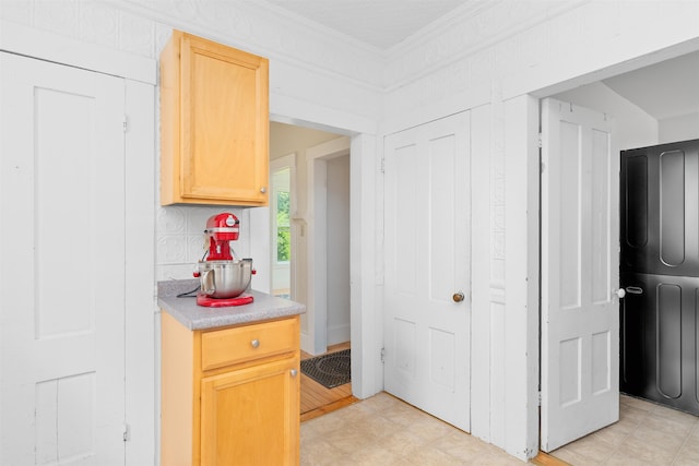 138 Sixth St, Dover, NH 03820 - kitchen featuring light countertops, ornamental molding, washer / dryer, and light brown cabinetry