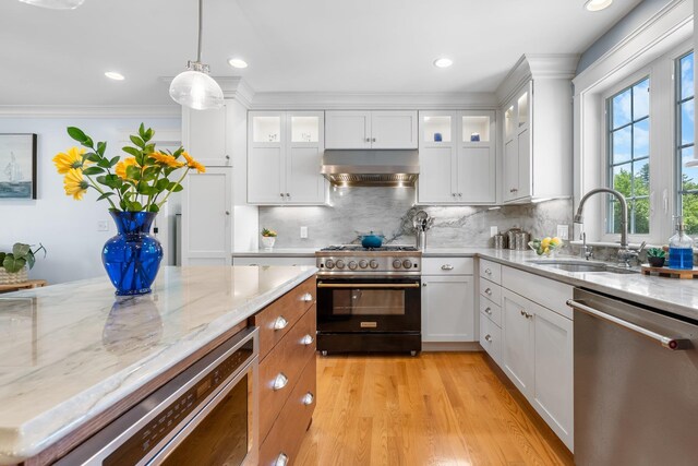 6 Tannery Way, Kensington, NH 03833 - kitchen featuring gas range oven, stainless steel dishwasher, extractor fan, a sink, and decorative light fixtures