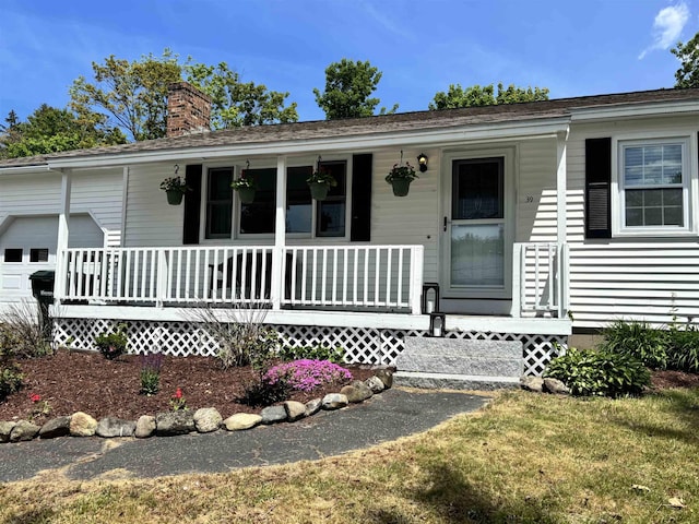 39 Orchard St, Laconia, NH 03246 - view of front of property featuring a porch, a chimney, and an attached garage