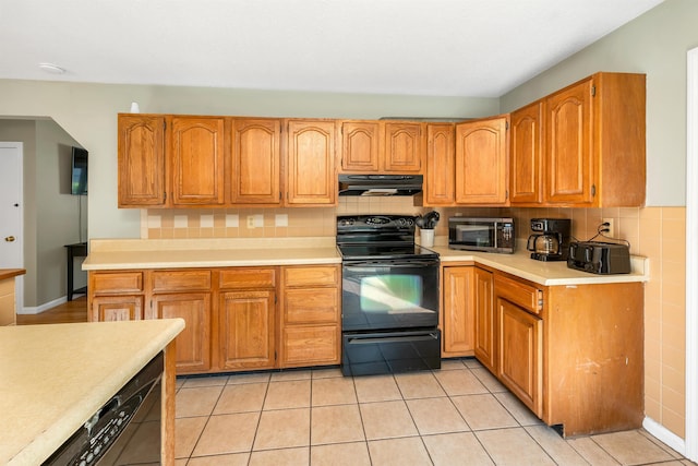 39 Orchard St, Laconia, NH 03246 - kitchen with electric range, under cabinet range hood, backsplash, light countertops, and brown cabinets