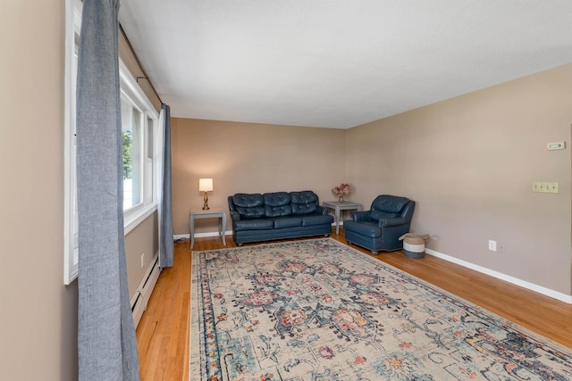 39 Orchard St, Laconia, NH 03246 - living room with light wood finished floors, baseboards, and a baseboard radiator