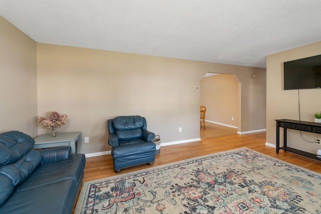 39 Orchard St, Laconia, NH 03246 - living room with arched walkways, wood finished floors, and baseboards