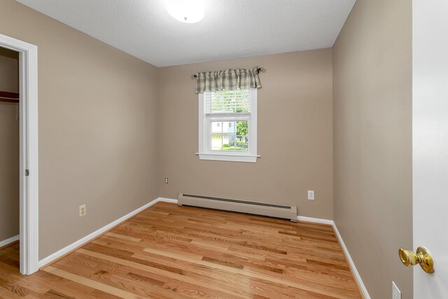 39 Orchard St, Laconia, NH 03246 - unfurnished bedroom with a baseboard heating unit, light wood finished floors, and baseboards