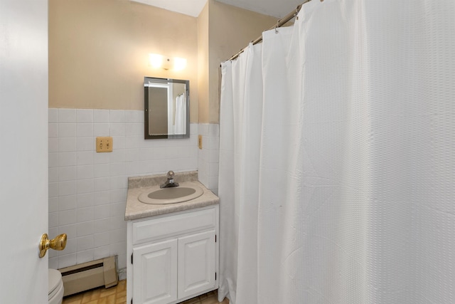 39 Orchard St, Laconia, NH 03246 - full bathroom with a baseboard heating unit, tile walls, toilet, vanity, and wainscoting