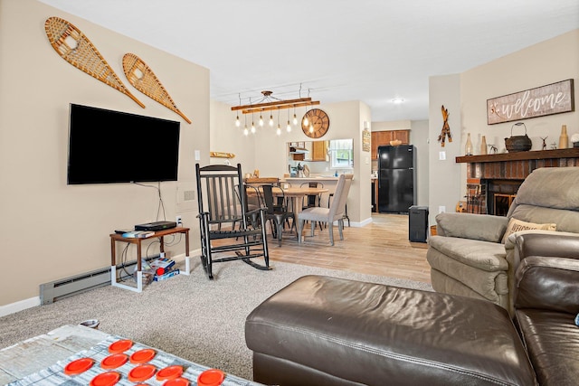 14 Monroe Dr Unit 92, Woodstock, NH 03293 - living area with baseboard heating, baseboards, and light wood-type flooring