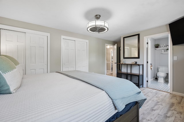 4 Franconia Dr, Nashua, NH 03063 - bedroom with two closets, light wood finished floors, baseboards, and ensuite bath