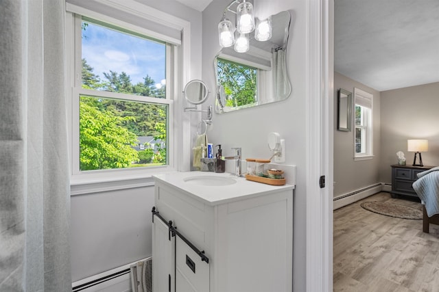 4 Franconia Dr, Nashua, NH 03063 - bathroom featuring a baseboard heating unit, vanity, wood finished floors, and healthy amount of natural light