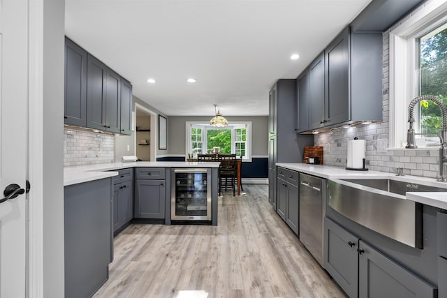 4 Franconia Dr, Nashua, NH 03063 - kitchen with wine cooler, a sink, stainless steel dishwasher, light wood-style flooring, and a peninsula