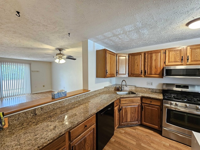 302 Eastview Dr, Wilton, NH 03086 - kitchen with stainless steel appliances, a sink, light wood-style floors, a textured ceiling, and ceiling fan