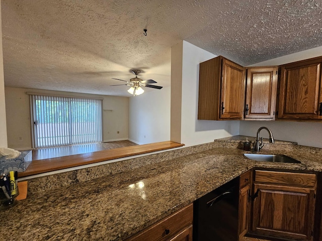 302 Eastview Dr, Wilton, NH 03086 - kitchen featuring black dishwasher, a sink, a textured ceiling, a ceiling fan, and dark stone countertops