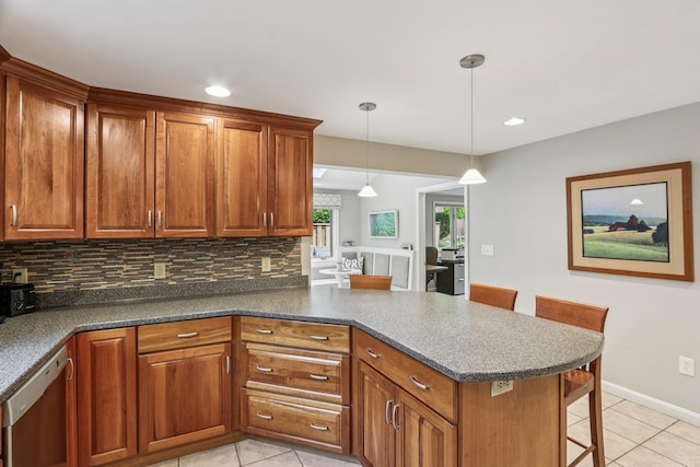 2 Warton Rd, Nashua, NH 03062 - kitchen featuring dishwasher, light tile patterned floors, a peninsula, brown cabinetry, and tasteful backsplash