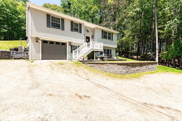 4 Mones Folly Dr, Dover, NH 03820 - bi-level home featuring driveway, stairway, a garage, central AC, and view of wooded area