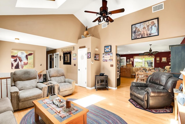 4 Mones Folly Dr, Dover, NH 03820 - living area featuring a wood stove, light wood-style floors, a ceiling fan, high vaulted ceiling, and a chandelier