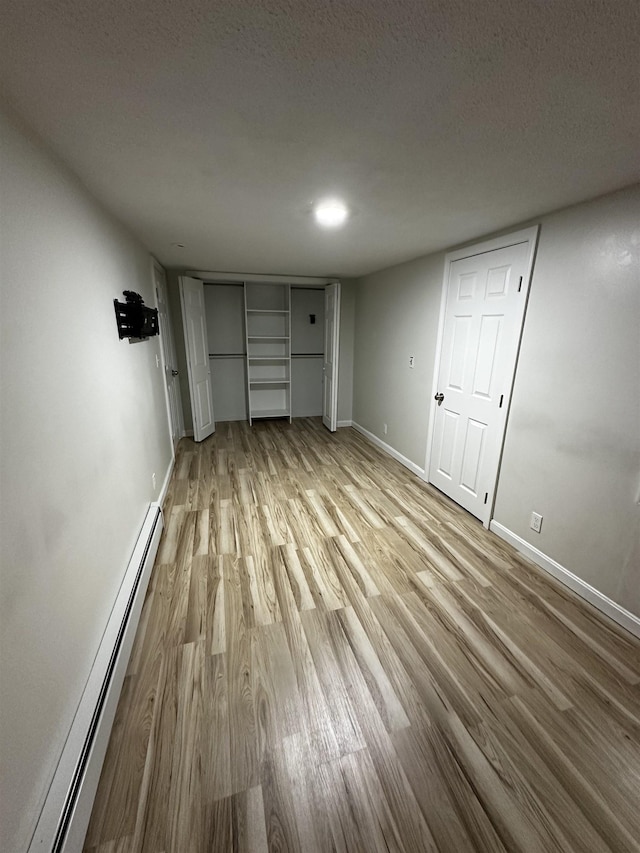 30 Flat Rock Bridge Rd, Rochester, NH 03868 - unfurnished bedroom featuring baseboard heating, wood finished floors, and baseboards