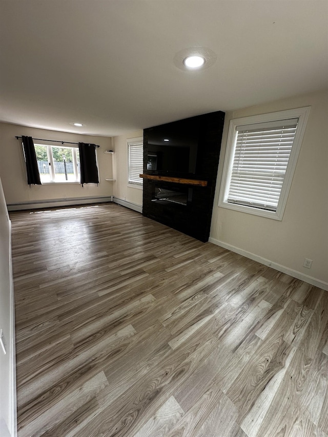 30 Flat Rock Bridge Rd, Rochester, NH 03868 - unfurnished living room with wood finished floors, a large fireplace, baseboard heating, baseboards, and recessed lighting