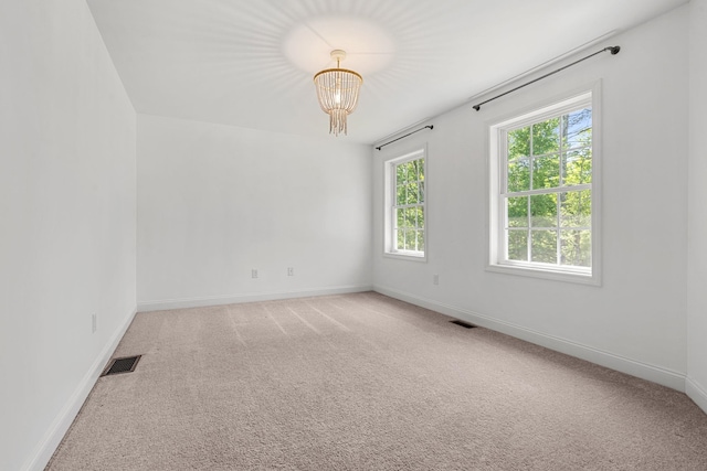 250 Harmony Rd, Northwood, NH 03261 - spare room with baseboards, light carpet, and a chandelier