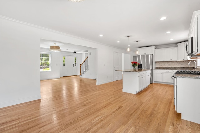 250 Harmony Rd, Northwood, NH 03261 - kitchen with stainless steel fridge with ice dispenser, a kitchen island, decorative backsplash, pendant lighting, and open floor plan