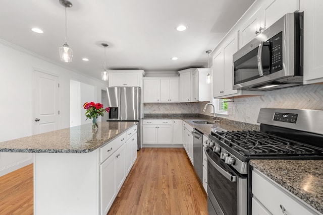 250 Harmony Rd, Northwood, NH 03261 - kitchen featuring stainless steel appliances, light wood finished floors, a sink, a center island, and crown molding