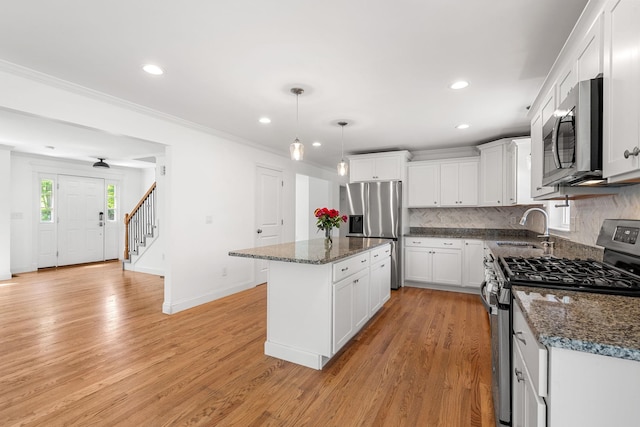250 Harmony Rd, Northwood, NH 03261 - kitchen with stainless steel appliances, a sink, tasteful backsplash, a center island, and white cabinets